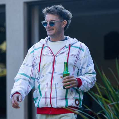 Man wearing a colorful hoodie made from dishcloth holding a beer bottle outdoors.